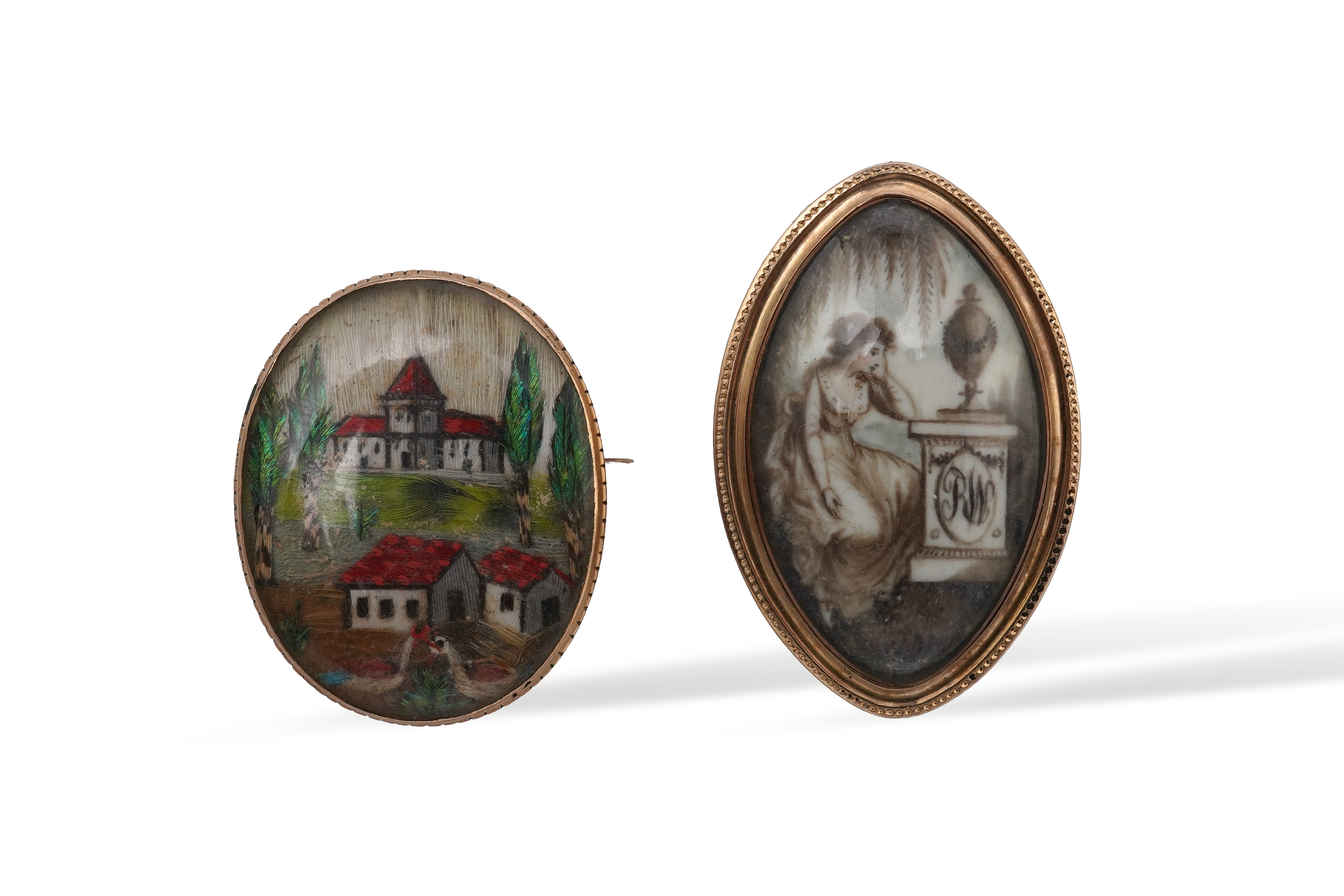 A George III ivory mourning brooch, circa 1786, and a feather work brooch, 19th century